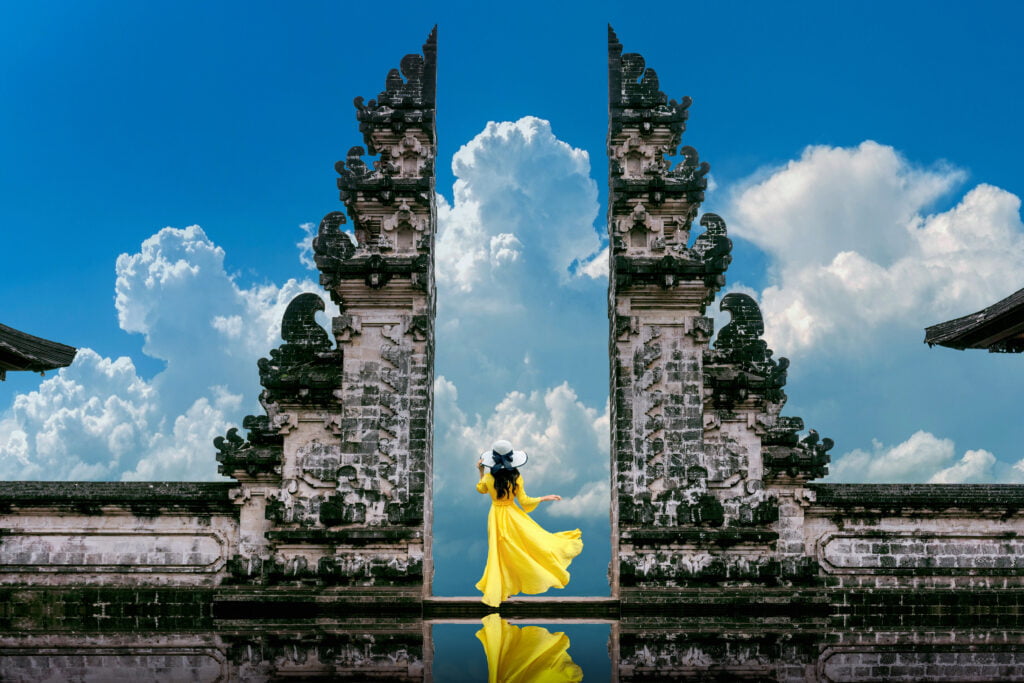 Young woman standing in temple gates at Lempuyang Luhur temple i