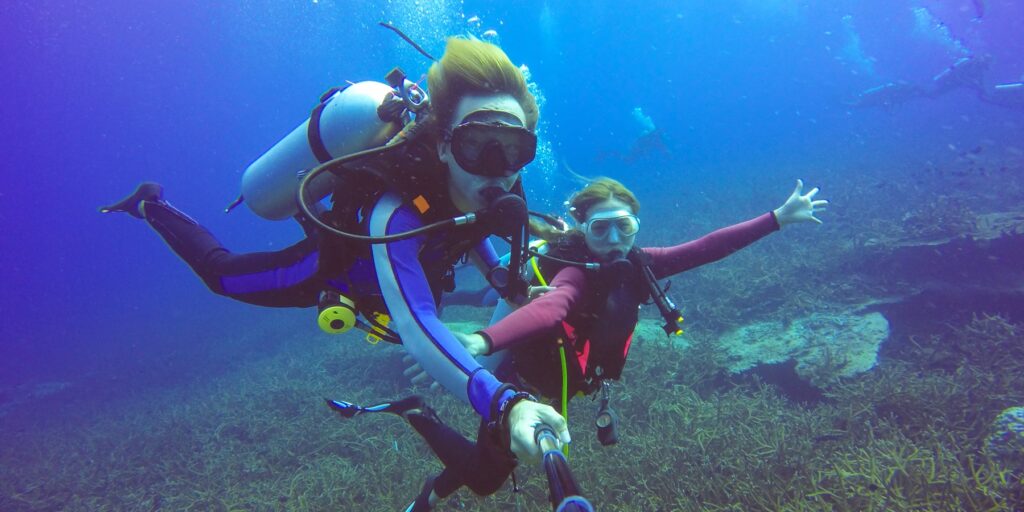 Underwater scuba diving selfie shot with selfie stick. Deep blue