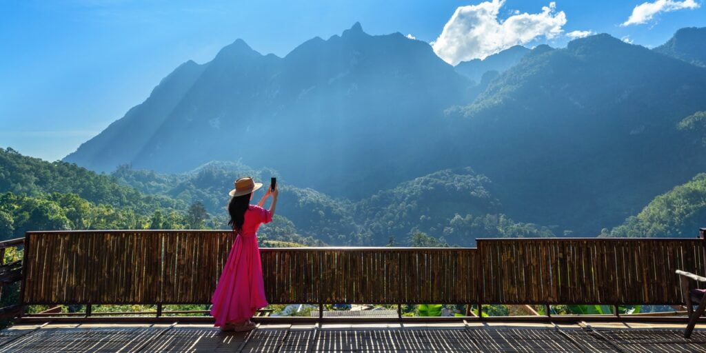 Woman tourist taking photo of Doi Luang Chiang Dao mountains, Ch