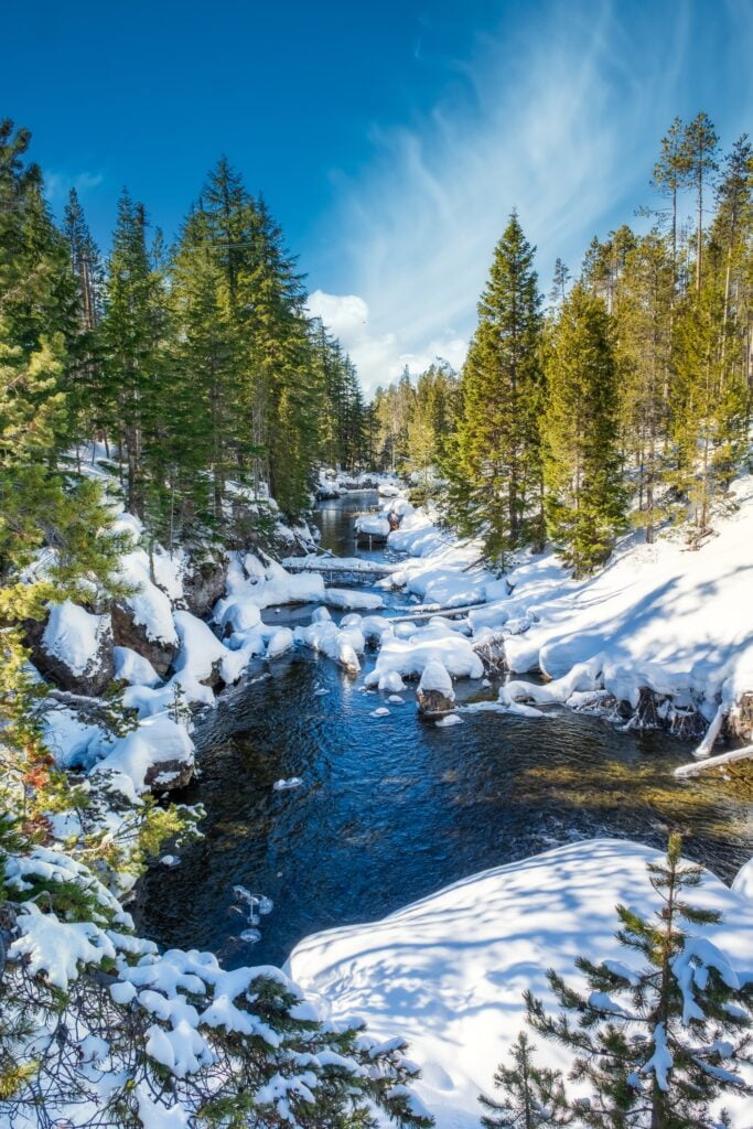 Mesmerizing shot of a beautiful snowy rocky park around  the lake with a background of a mountain