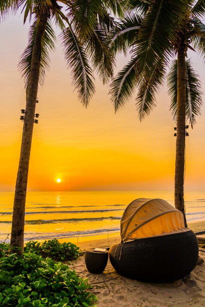 Umbrella and chair on the beautiful beach and sea at sunrise tim